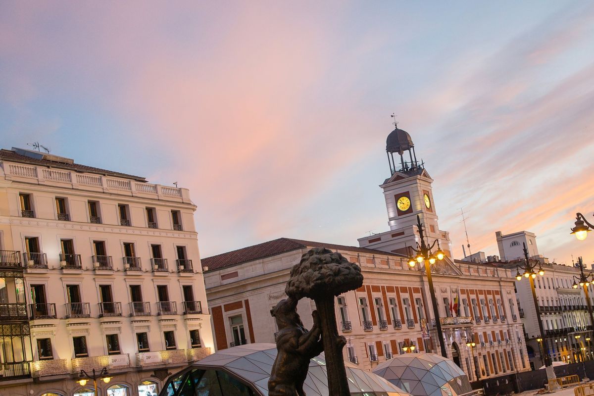 Die Puerta del Sol mit dem Uhrturm der Real Casa de Correos und der Statue des Bären mit dem Erdbeerbaum am Abend